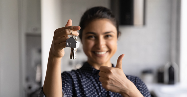 young woman holding keys to her new home