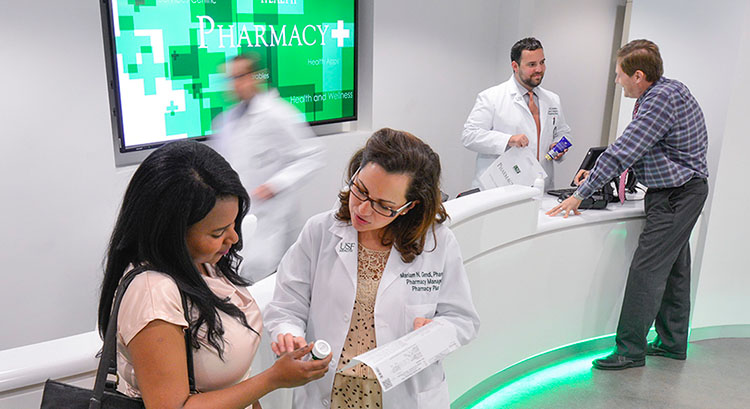 Pharmacists provide assistance to customers at USF Health Pharmacy Plus.