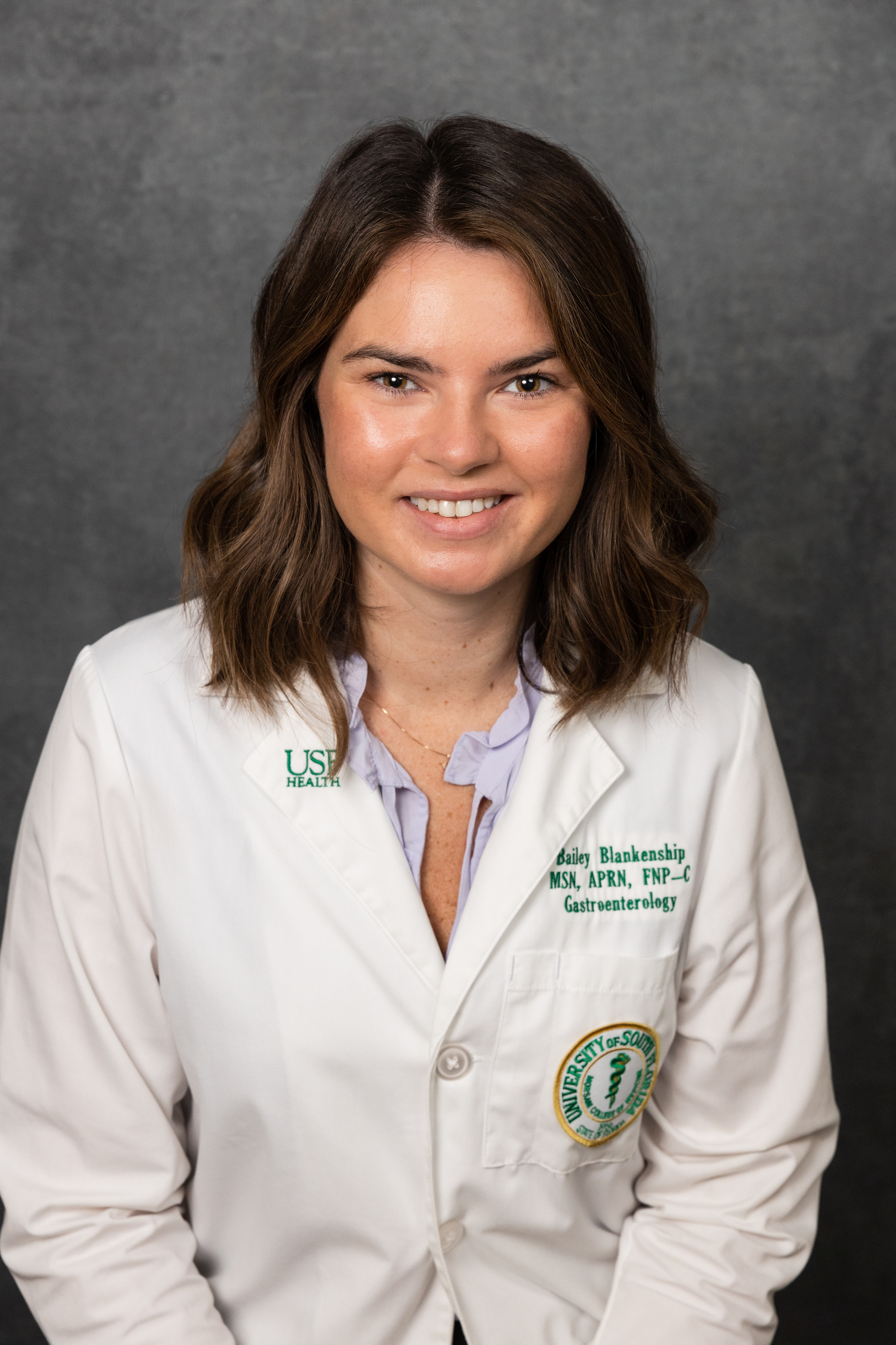Headshot of Bailey Blankenship, MSN, APRN, FNP-C in whitecoat with USF Health Department of Internal Medicine Division of Gastroenterology