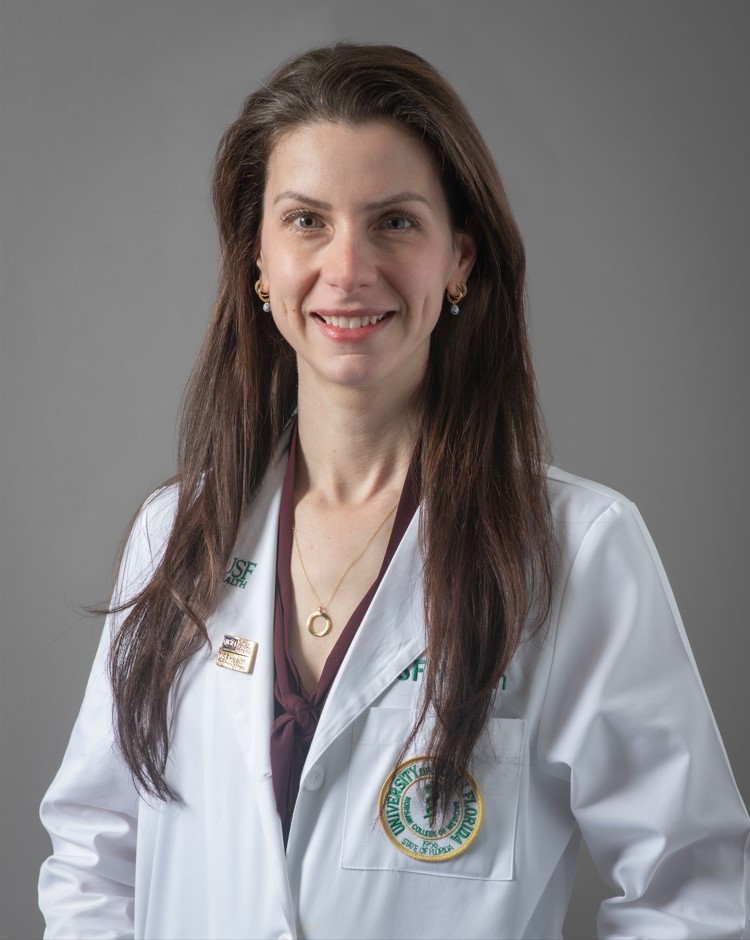 White Coat Headshot of Dr. Monica Polcz.