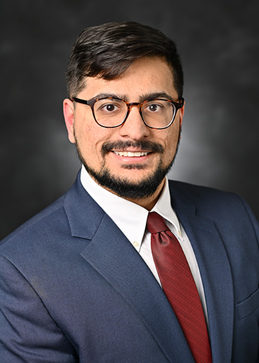 Sameer Andani, USF Health Pathology Resident in a blue suit and red tie