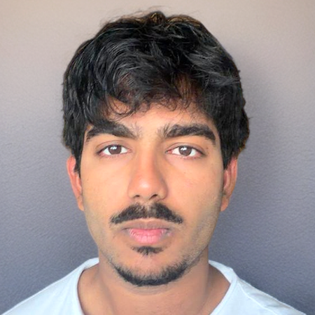 Male student with dark hair and brown eyes wearing a white shirt 