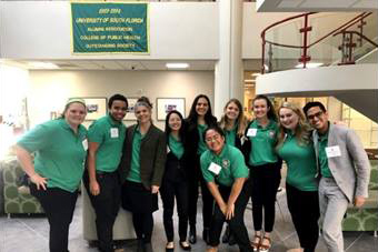 A group of people standing in the College of Public Health lobby