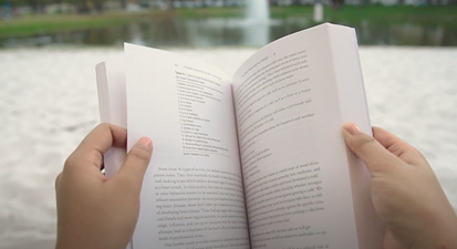 A person's hands holding an open book
