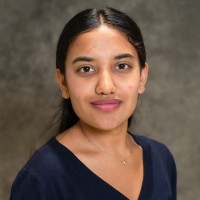 A headshot of Manisha Katwal in front of a grey backdrop