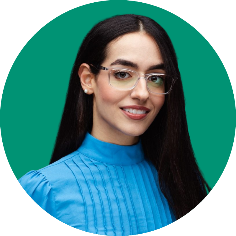 An image of Shahrzad Zamani smiling in front of a green backdrop