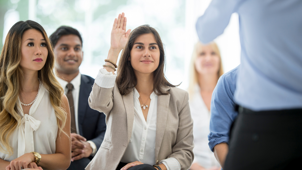 A woman raising her hand in a meeting