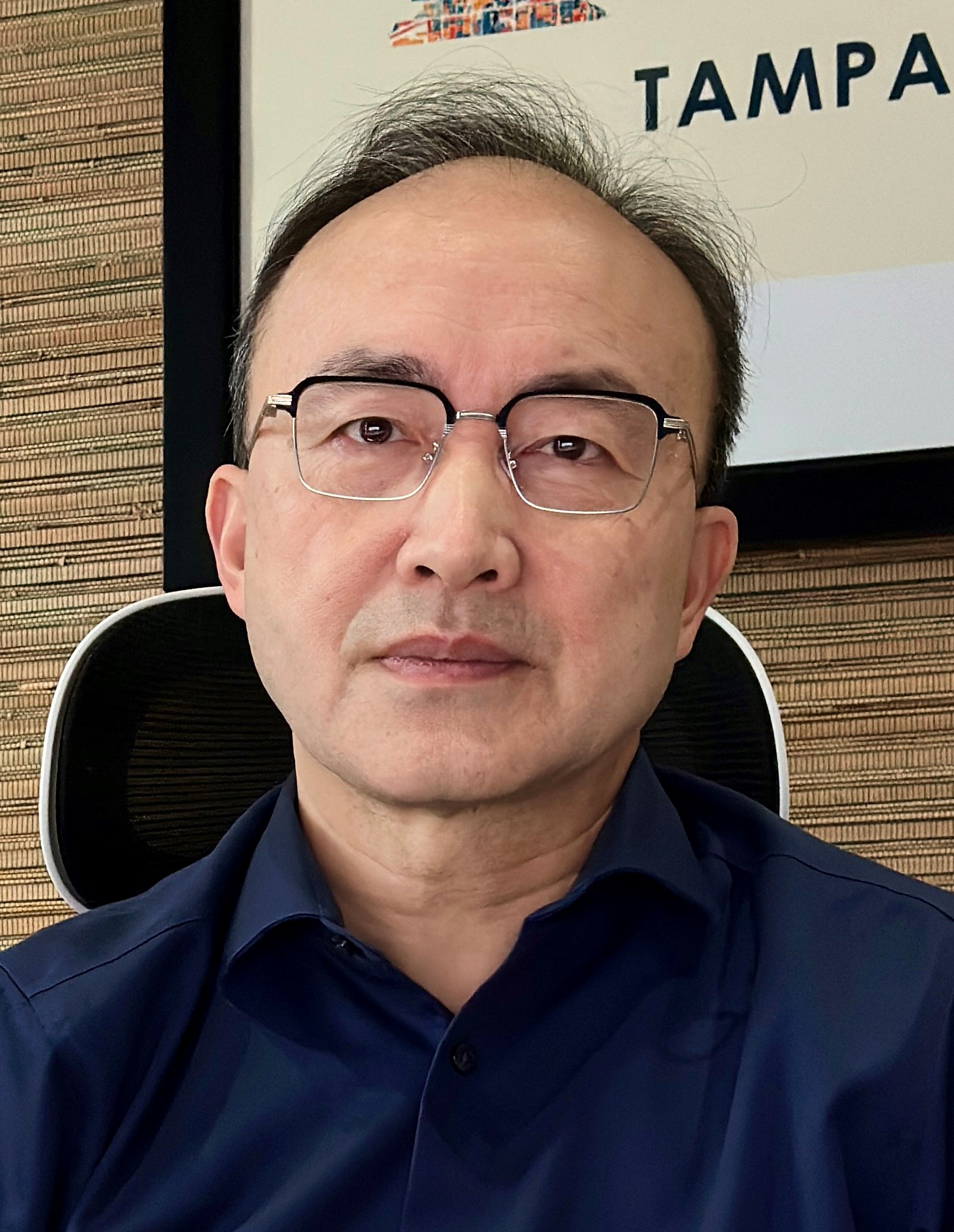 A headshot of Dr. Wei Wang in an office setting