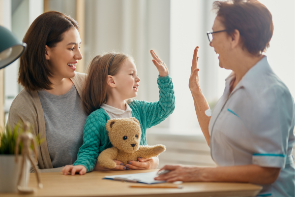 A public health professional, a mother, and her daughter having a discussion. The daughter and public health professional are high-fiving each other.