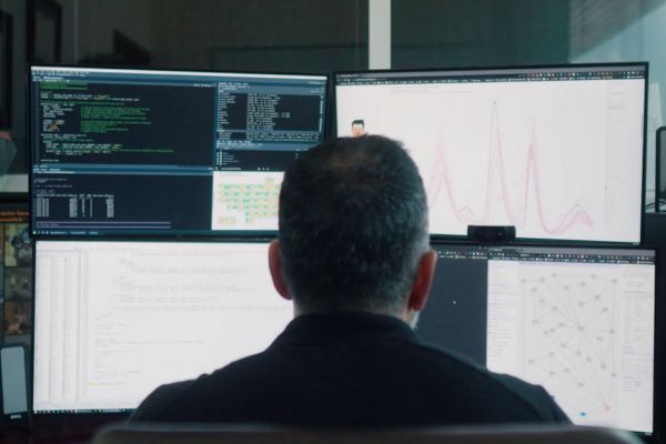 A person staring at graphs and research on a computer screen.