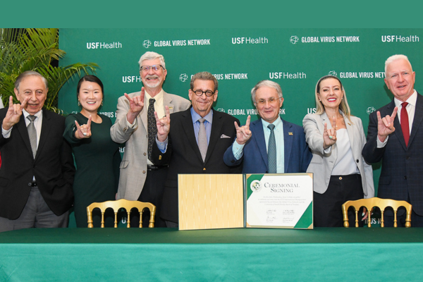 Leadership and representatives from the Global Virus Network and COPH holding up the "Go Bulls!" hand symbol.