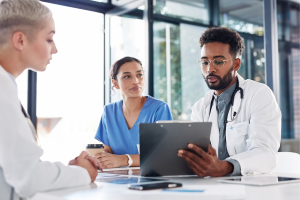 A group of public health professionals sitting around a table looking at a tablet
