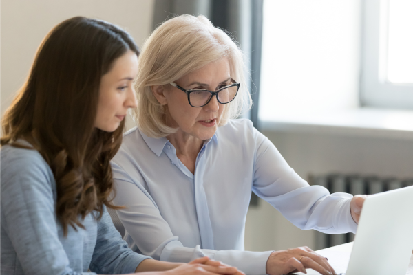 An older woman mentoring a younger woman.