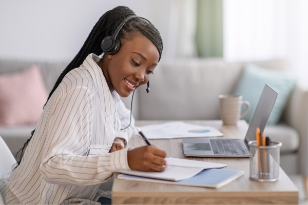 A woman wearing a headset and working on a computer.
