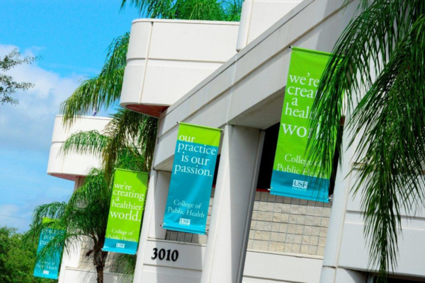 "Our Practice is Our Passion" banners in front of the USF College of Public Health Samuel P. Bell, III building.
