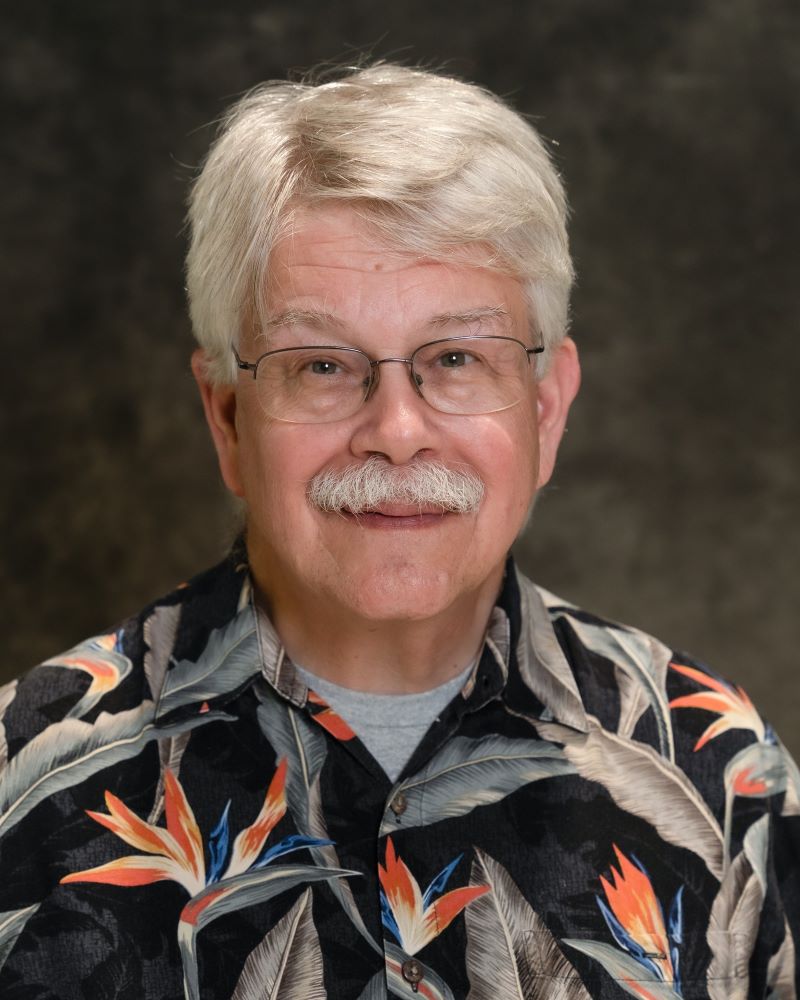 Headshot of Dr. Russell Kirby in front of a dark grey backdrop