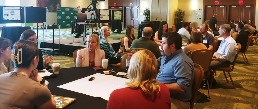 A wideshot image of people sitting at tables during a Sunshine ERC event