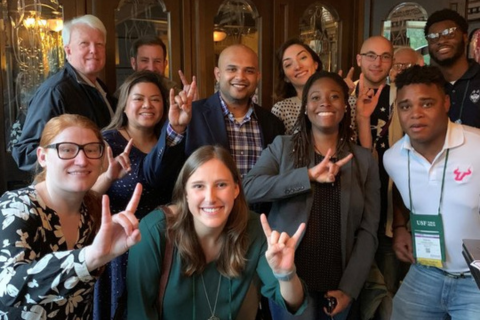 Various students, faculty, and staff holding up the "Go Bulls" hand symbol