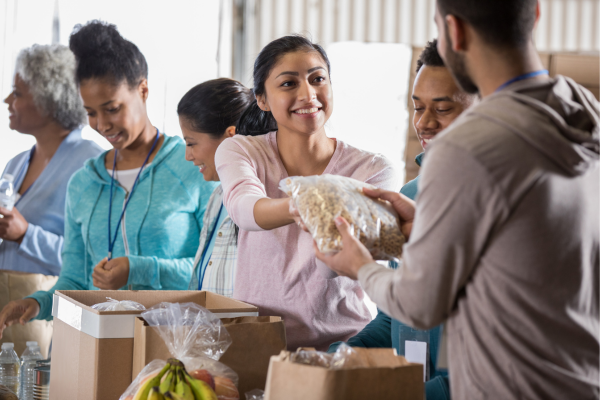 A group of people packing pantry food items in boxes in preparation for hurricane season.