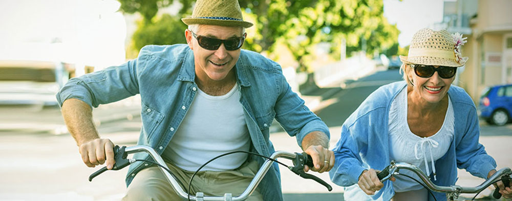 Copule riding bicycles with sunglasses protecting their eyes