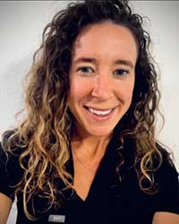 Dr. Kristine Terry smiling in black medical scrubs