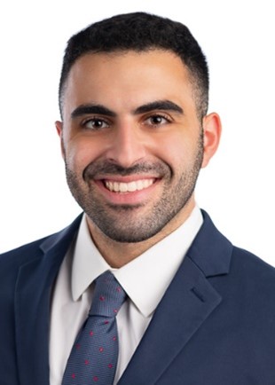 Michael smiling wearing a blue suit and white shirt
