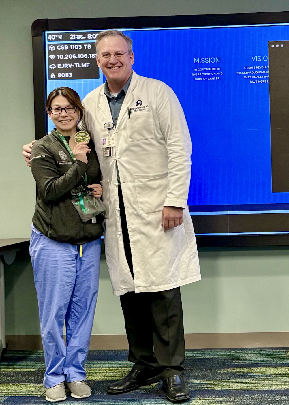 Maya Yasukawa holding a culture coin standing next to her attending