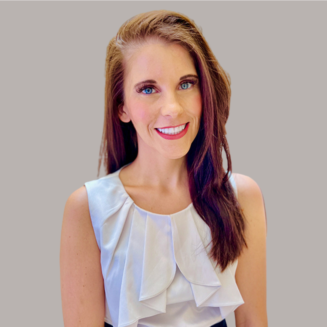 Janelle Applequest smiling wearing a white blouse