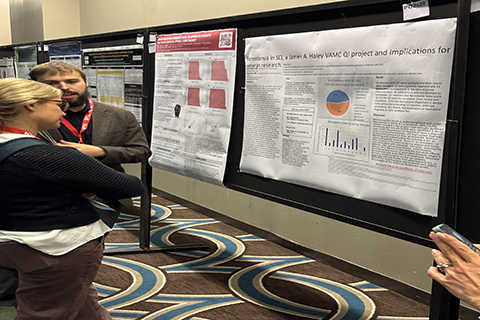 Researchers standing in front of poster reviewing data