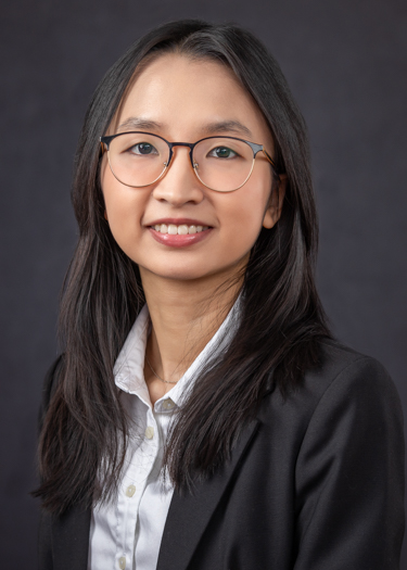 Dr. Tonnu wearing a black blazer and button down shirt as a headshot