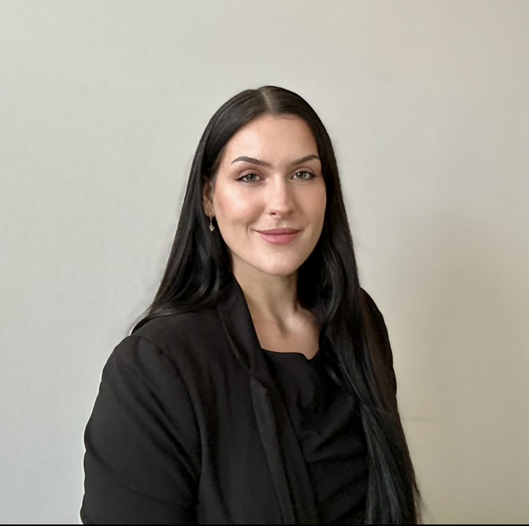 A headshot of Dr. Parker in a black blazer and black shirt
