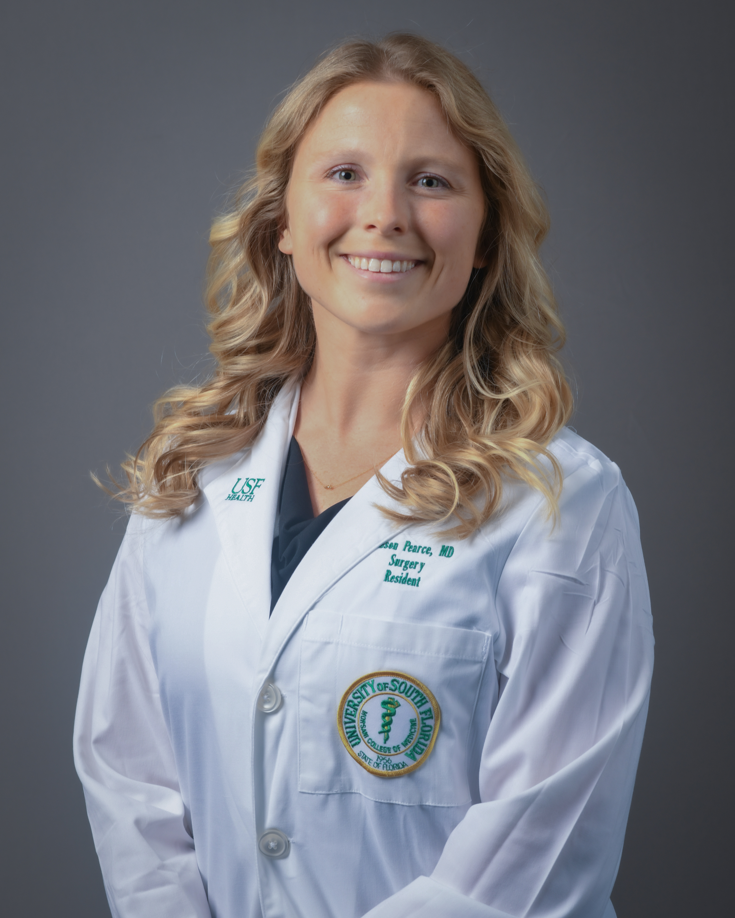 Professional headshot of Mason Pearce. Blonde female, white coat with USF logo. 