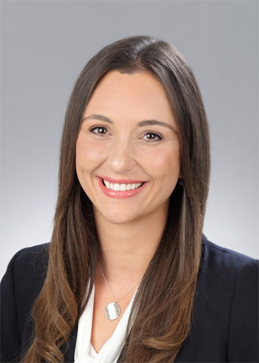 Dr. Vasilakos wearing a black blazer and white shirt in a headshot photo