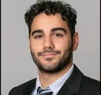 A headshot of Dr. Salmanian in a black suit, collar shirt, and patterned tie