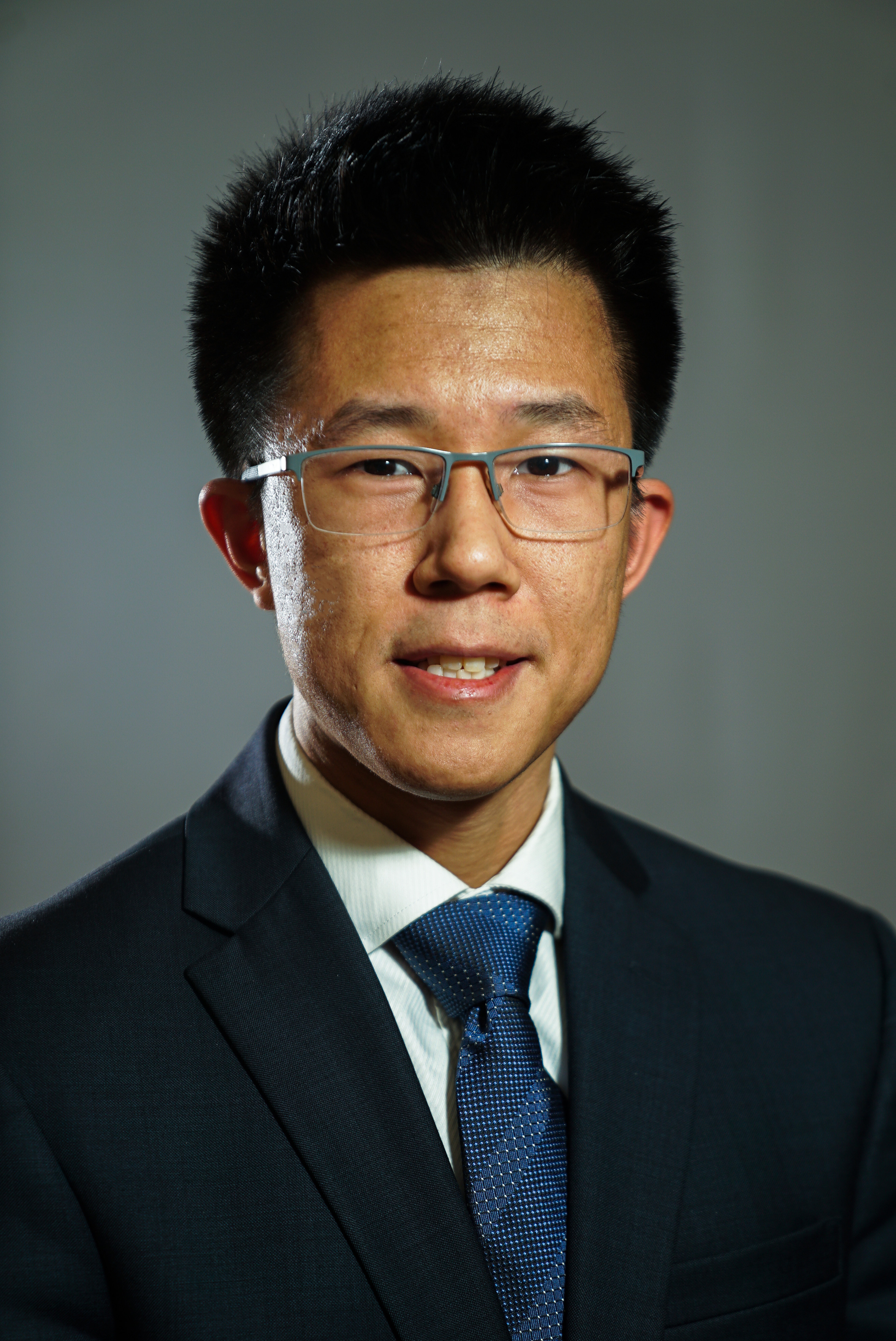 headshot of Ma in suit with tie