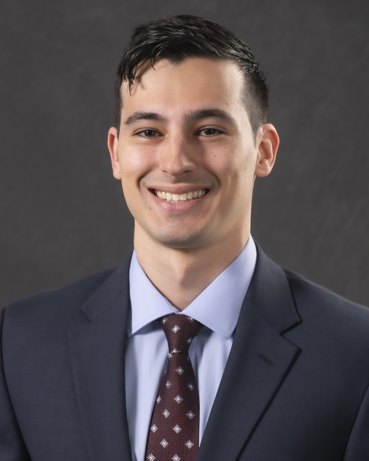 headshot of Matar in suit with tie