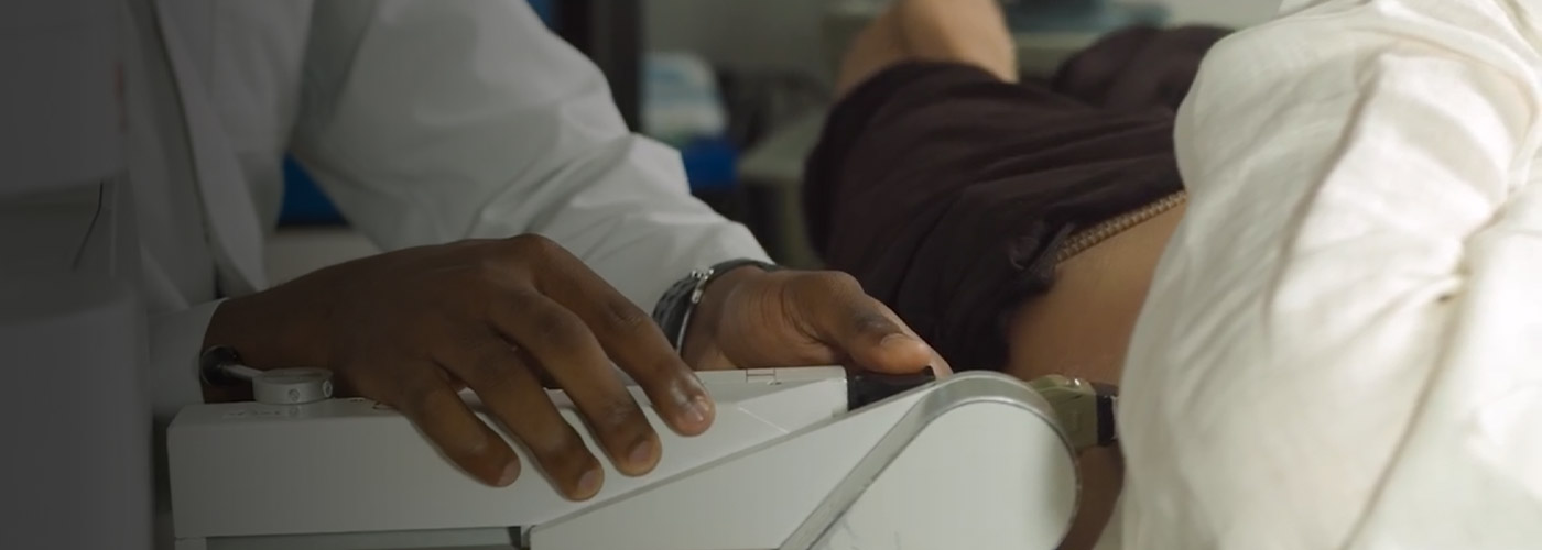 Close up of a doctors hands using a machine to examine a patient