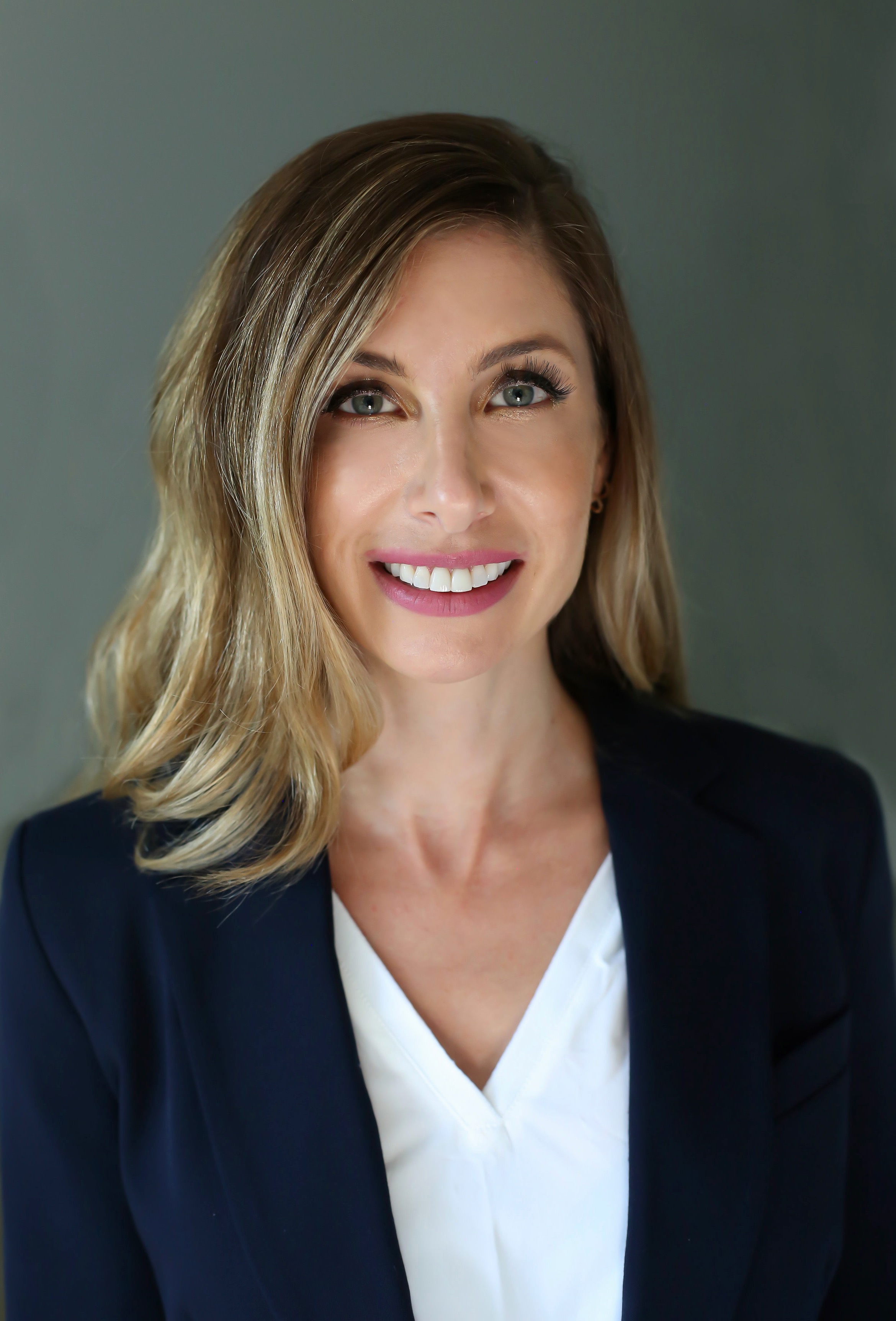 Jenny Gutwein smiling wearing awhile blouse and black blazer
