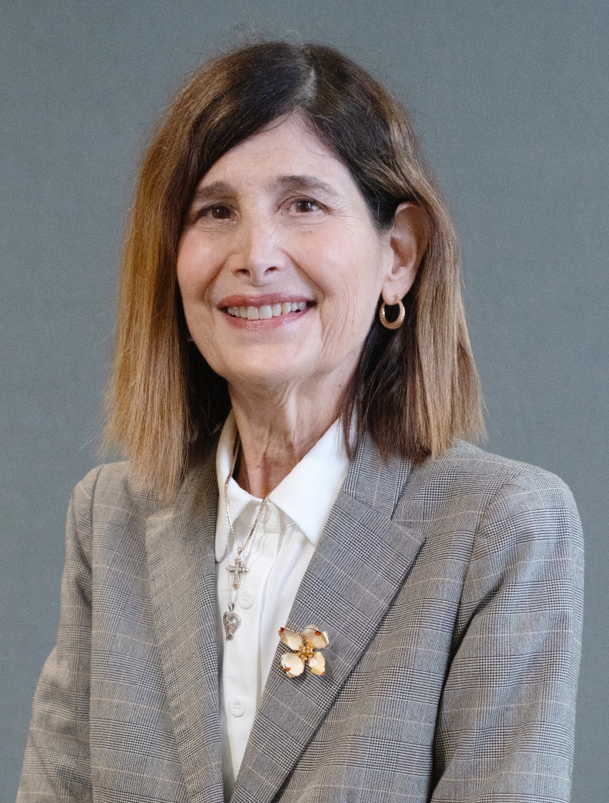 Headshot of Dr. Karen Liller wearing a grey blazer and white shirt in front of a grey backdrop.