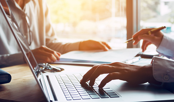 Hands resting on a keyboard of a laptop