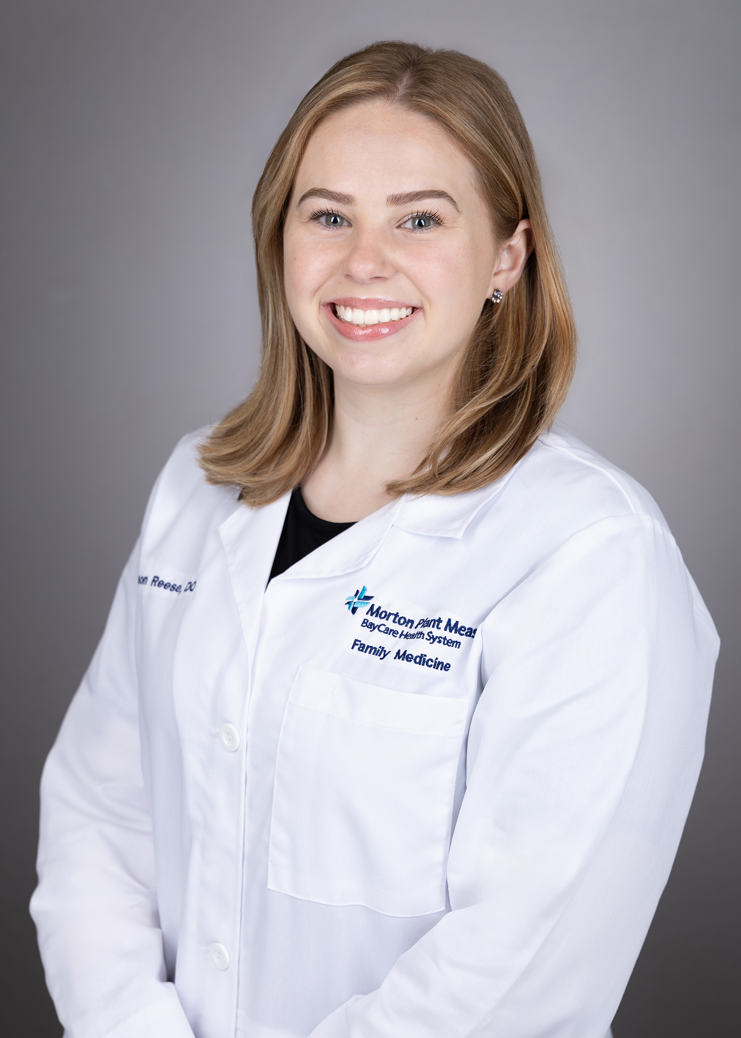 Alyson Reese smiling wearing a medical white coat