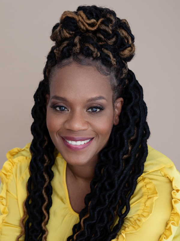 A headshot of Dr. Tricia Penniecook smiling in front of a beige backdrop