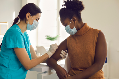 A nurse administering a vaccine to a woman