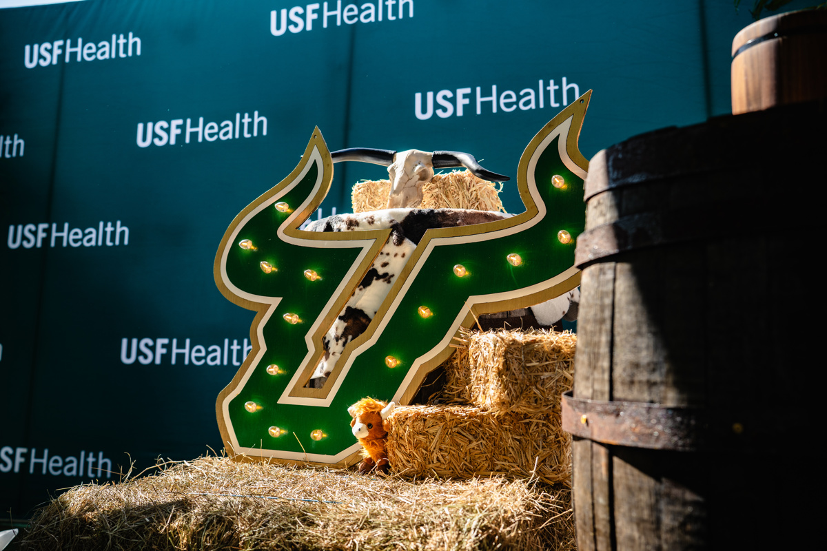 USF "U Bull" marquee illuminated in front of USF Health step and repeat sign
