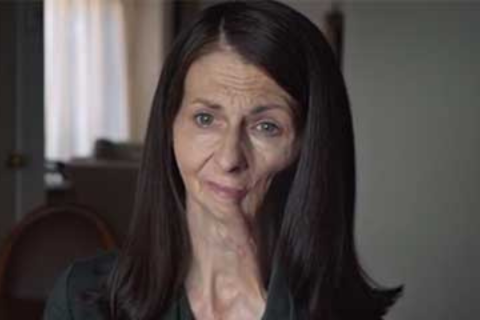 A woman with long hair looking at the camera. She is a smoking study participant.