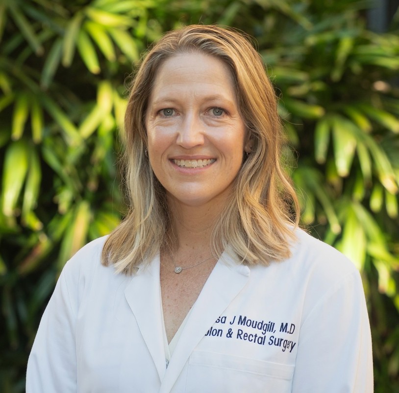 Headshot of Dr. Lisa Moudgill wearing a white coat with a nature background.