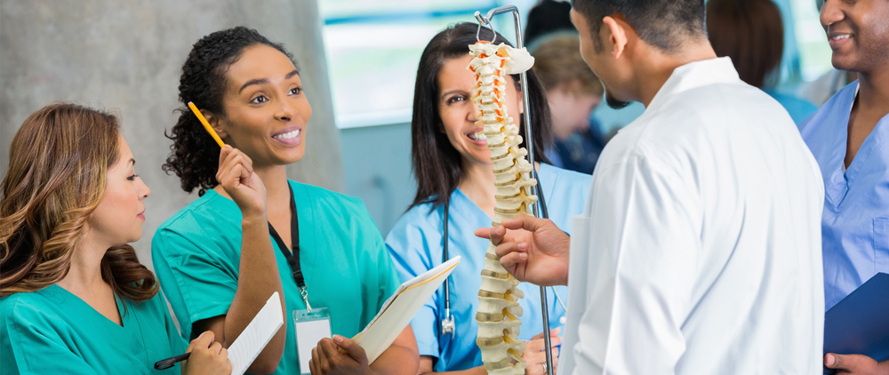  A group of doctors and nurses surrounds a patient, discussing care and treatment in a hospital setting.