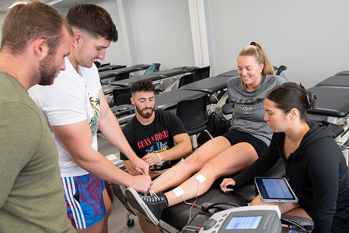 Doctor performing physical therapy on patient's leg.