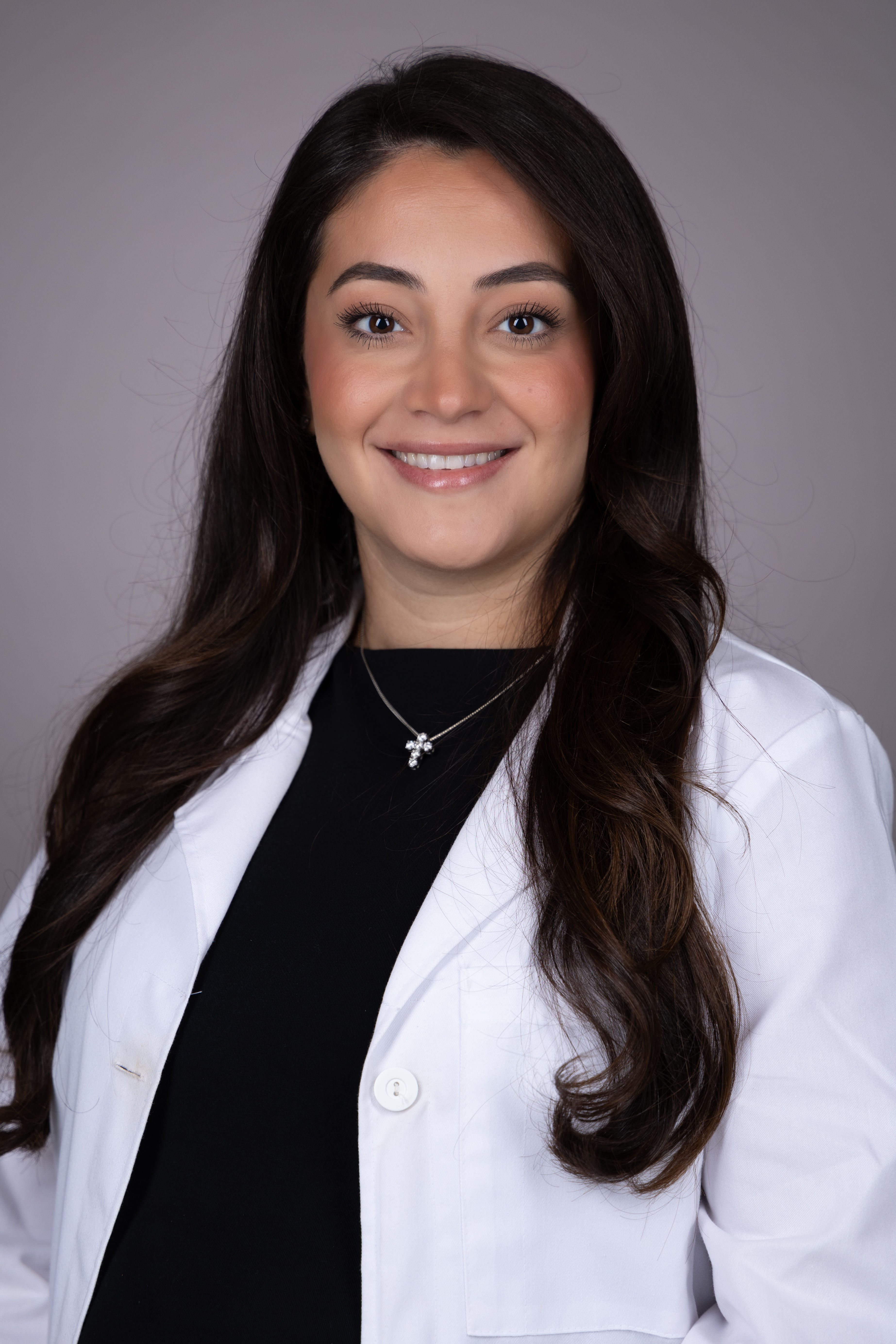 Jennifer Zervos smiling wearing a medical white coat