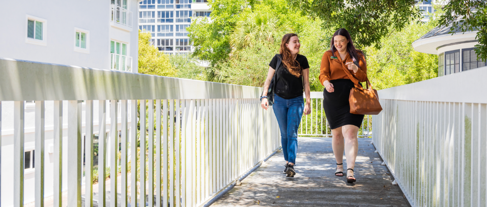 A USF student and staff member walking on campus